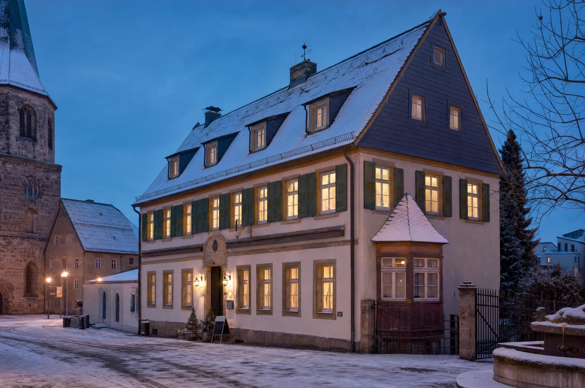 Die Fassade des Restaurants Zum Kreuzstein in der Kreuzsteinstraße — Abenddämmerung, warm erleuchtete Fenster
